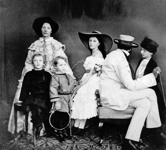 Baron von Budberg mit seiner Familie, Berlin, 1858 – Familienportrait, sitzender Vater abgewandt, stehende Frau in die Kamera blickend, vier Kinder teilweise unscharf