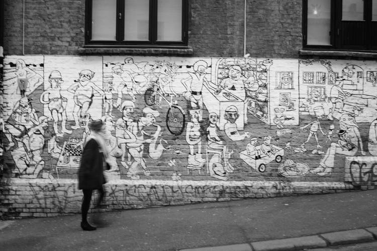 Urbane Kunst im Brenneriveien, Oslo – Frau vor einer Backsteinwand mit gezeichneten Graffiti