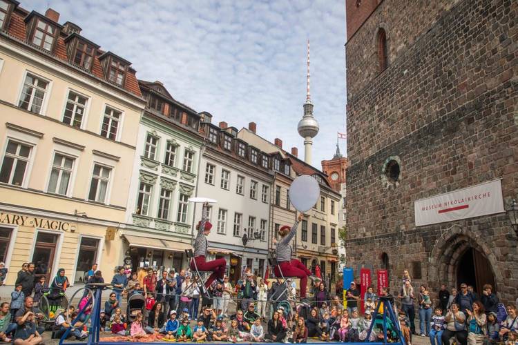 Der Wanderzirkus CABUWAZI bringt die Besucher:innen des Nikolaiviertels zum Staunen. – Der Wanderzirkus CABUWAZI während einer Show auf dem Nikolaikirchplatz