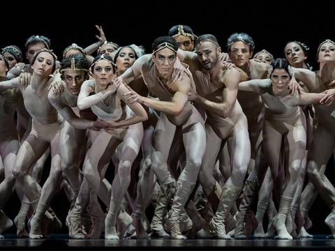2 Chapters Love – Ballettgruppe auf der Bühne, alle tragen hautfarbene Trikots und Stirnbänder, eng zusammen, verschiedene Posen und Gesichtsausdrücke, dunkler Hintergrund.