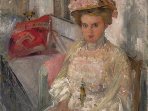 Lovis Corinth, Porträt Frau Douglas (Irma Hübner), 1909 – Gemälde einer weiblich gelesenen Person in hellem Kleid und Hut, sitzend auf Sofa. Pinselstriche im impressionistischen Stil. Signatur oben rechts: Lovis Corinth 1909