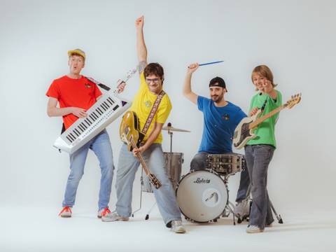 Das große Kinderrechte-Konzert – Vier Personen mit Instrumenten: Gitarre, Keyboard, Schlagzeug, Bass. Farbenfrohe Kleidung in Rot, Gelb, Blau, Gruen. Weisser Hintergrund, energiegeladene Posen.
