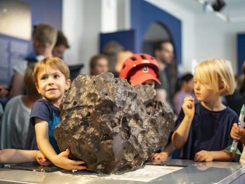 Kinder in der Archenhold-Sternwarte – Drei Kinder stehen vor Exponaten in der Archenhold-Sternwarte