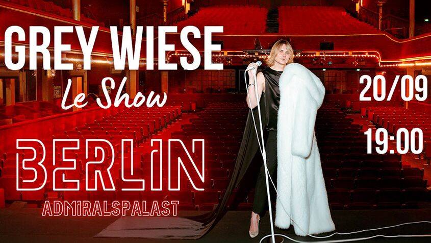 Person mit Mikrofon und weißem Mantel im leeren Theater. Text: GREY WIESE Le Show BERLIN ADMIRALSPALAST 20/09 19:00.