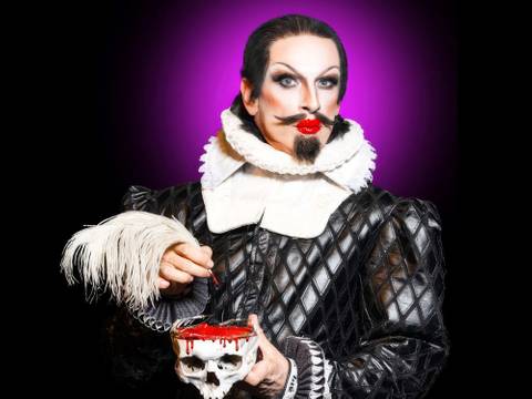 PINK GRIMM: Shakesqueer – God save the Queens – Person in barocker Kleidung mit Feder in der Hand; bemalte Totenkopf-Schale mit roter Flüssigkeit; violetter Hintergrund.