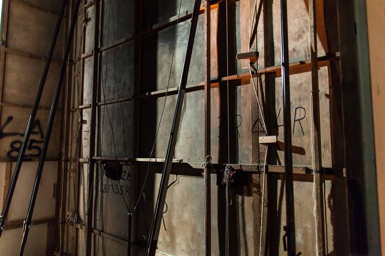 Backstage-Führung – Holzwand mit Seilkonstruktionen. Aufschrift: „3 R 4 L R“. Schatten und Lichtspiel auf der Oberflaeche.