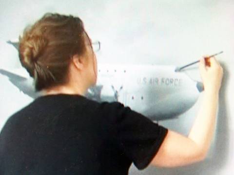 Dr. Iris Ulbricht im Atelier. – Frau malt Flugzeug.