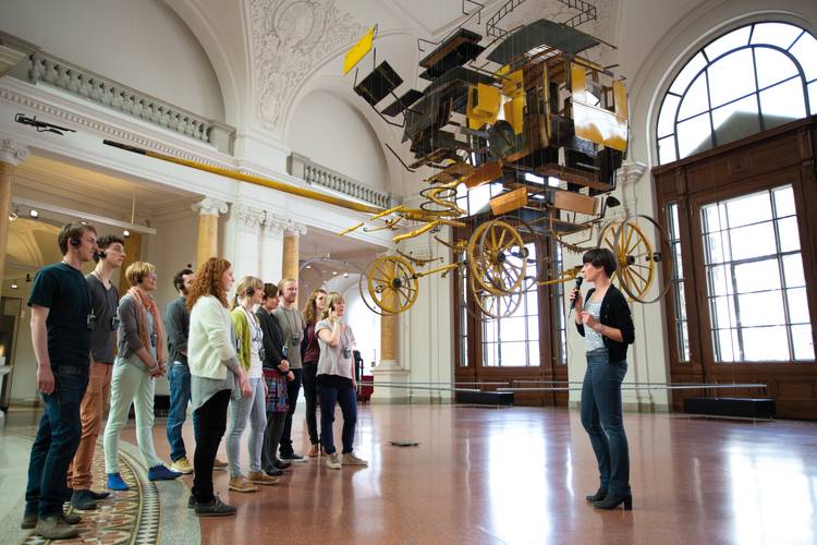 Highlight-Tour im Museum für Kommunikation Berlin – Eine Menschengruppe unter eine von der Decke abgehängten Postkutsche