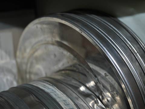 Blick auf alte Filmdosen im Archiv des Mitte Museums. – Stapel silberner Filmrollen in Großaufnahme. Die Kanten der metallenen Dosen sind sichtbar; im Hintergrund unscharfe Schrift auf Papier.