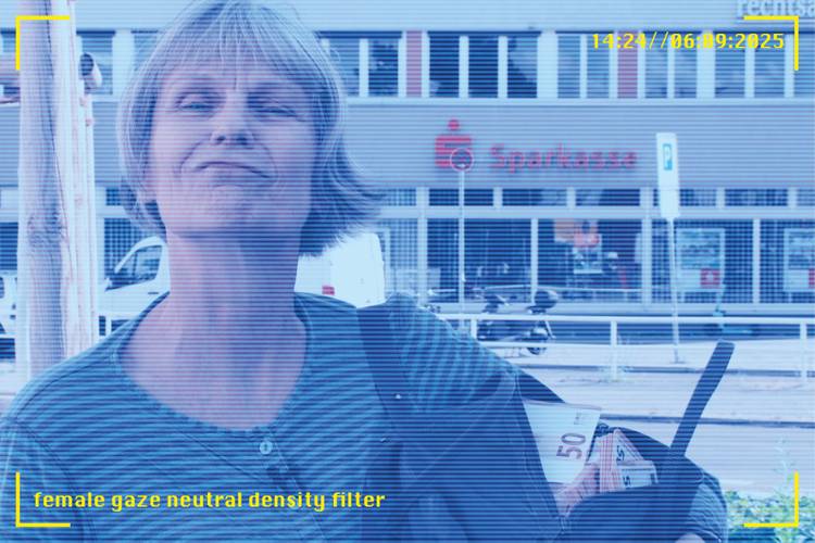 Eine Person mit kurzen Haaren vor einer Sparkasse. In der Hand Geld mit der Zahl 50. Text: female gaze neutral density filter, 14:24//06.09.2025.