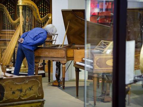 Besucher im Museum – Besucher im Museum bei der Betrachtung eines Cembalos