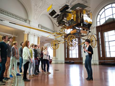 Highlight-Tour im Museum für Kommunikation Berlin – Eine Menschengruppe unter eine von der Decke abgehängten Postkutsche