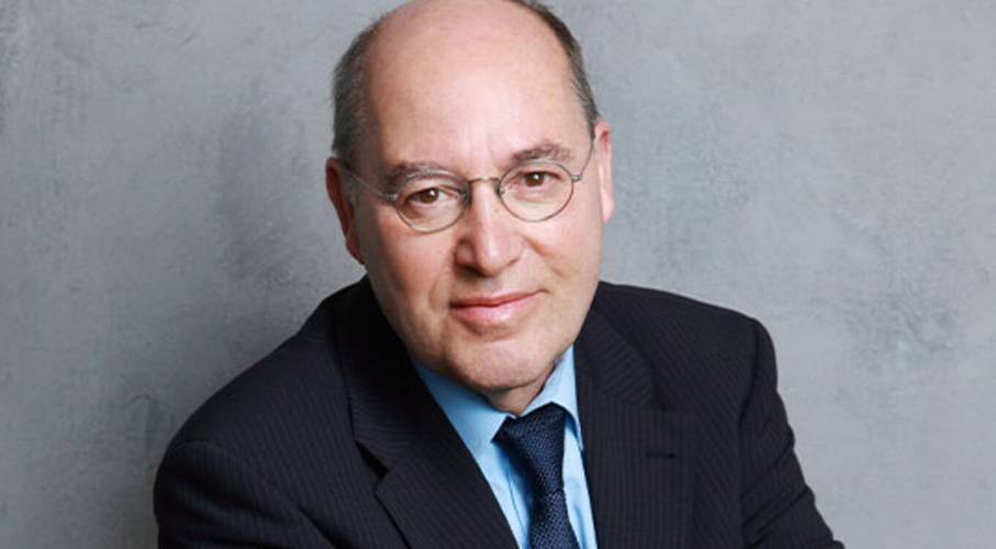 Gregor Gysi „Was Politiker nicht sagen“ – Person mit Brille und Glatze in Anzug mit Krawatte, vor grauem Hintergrund.