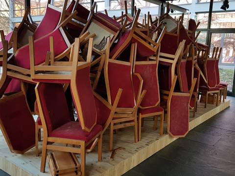 Installation Sturzlage – Aufeinandergestapelte Stühle vom Runden Tisch