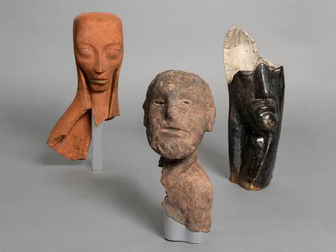 Emy Roeder, „Schwangere“, 1918; Karel Niestrath, „Frommer Mann“, 1924; Otto Freundlich, „Kopf“, 1925 (v.l.n.r.) – Drei abstrakte Skulpturenköpfe. Links braun, mit langen Augen; Mitte grob, dunkelbraun; rechts schwarz, hoch, mit ovaler Kappe. Neutrale Grautöne.