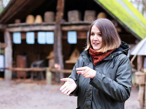 In Gebärdensprache bringt die Führung den Teilnehmenden das dörfliche Leben des Mittelalters nahe. – Momentaufnahme während einer Führung im Museumsdorf Düppel