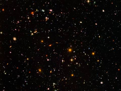 Hubble Ultra Deep Field (2018). Kompositbild des fernen Universums, erstellt auf Grundlage von Beobachtungen des Hubble-Weltraumteleskops – Verschiedene Galaxien und Sterne in einem dunklen Universum verteilt, leuchtend in unterschiedlichen Farben und Formen.
