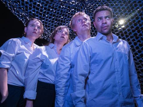 "Die Fische" am Theater Strahl – Vier Personen in weißen Hemden blicken nach oben. Der Hintergrund ist von einem dunkel gemusterten Stoff bedeckt. Licht von oben rechts.
