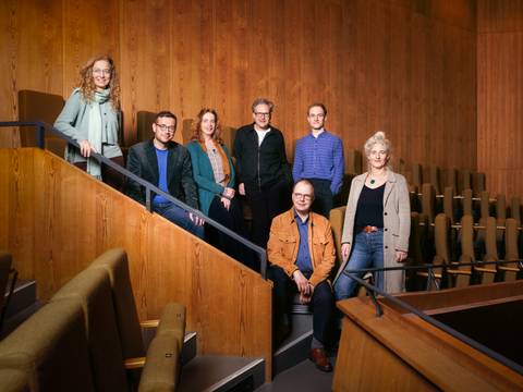 Die Theatertreffen-Jury 2026: Alexandra Kedves, Martin Thomas Pesl, Sabine Leucht, Falk Schreiber, Vincent Koch, Sascha Westphal, Christine Wahl – Die sieben Theatertreffen-Jurymitglieder stehen oder sitzen im Rang eines Theaters und schauen in die Kamera.
