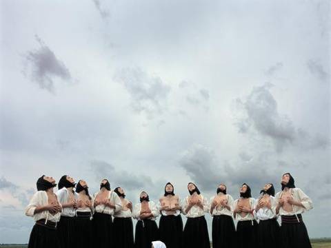 Marina Abramović, Women Massaging Breasts aus der Serie Balkan Erotic Epic, C-Print, 2005, Serbia – Frauen mit schwarzen Kopftüchern und knielangen Röcken massieren ihre nackten Brüste. Dabei schauen sie in den Himmel.