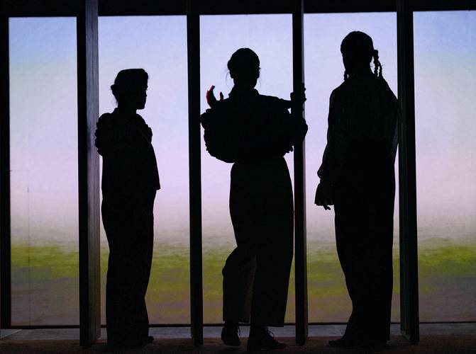 DAS ICH IM WIR – Drei silhouettierte Personen stehen vor einem hellen Hintergrund, in unterschiedlichen Posen, getrennt durch vertikale Linien. Eine trägt Zöpfe.