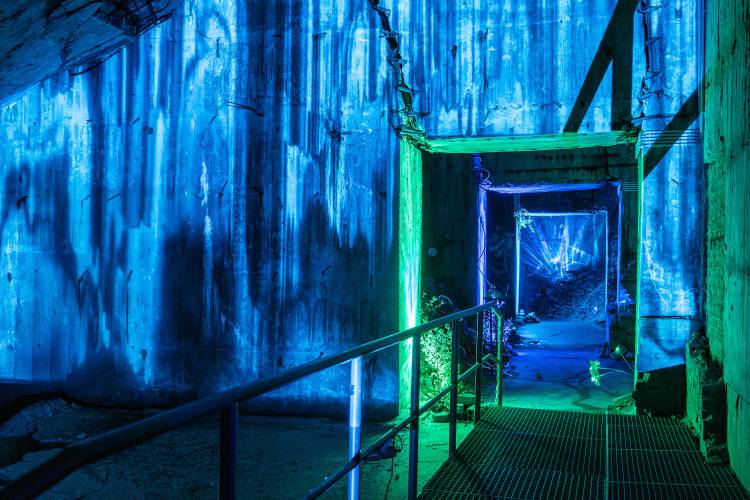 Klang- und Lichtinstallation: Seafoam Palace presents »Roadside Picnic« – Blick durch eine beleuchtete Betonstruktur mit blau-grüner Lichtinstallation und Metallgeländer im Flakturm Humboldthain.