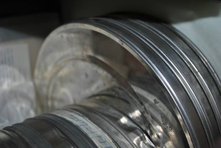Blick auf alte Filmdosen im Archiv des Mitte Museums. – Stapel silberner Filmrollen in Großaufnahme. Die Kanten der metallenen Dosen sind sichtbar; im Hintergrund unscharfe Schrift auf Papier.