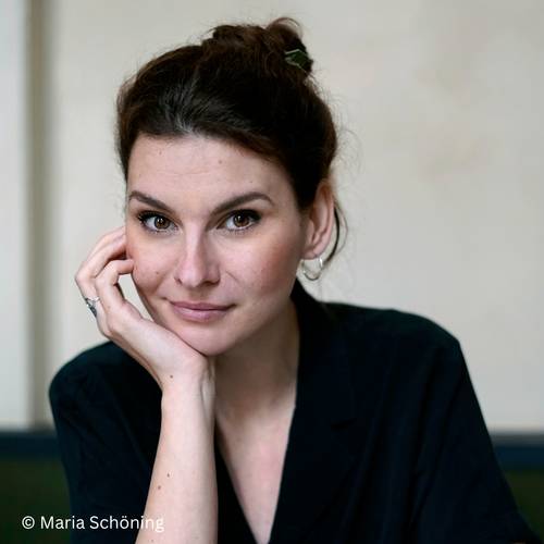 Judith Poznan – Eine Person in schwarzer Kleidung stützt den Kopf auf die Hand. Urheberrecht: Maria Schöning.
