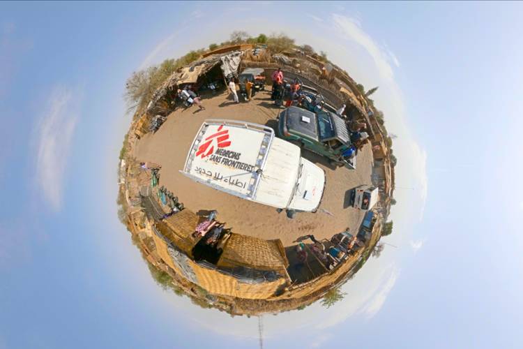 Kleine Kugelpanoramaaufnahme einer humanitären Hilfssituation mit einem weißen Fahrzeug von Ärzte ohne Grenzen und mehreren Personen in einer trockenen, ländlichen Umgebung
