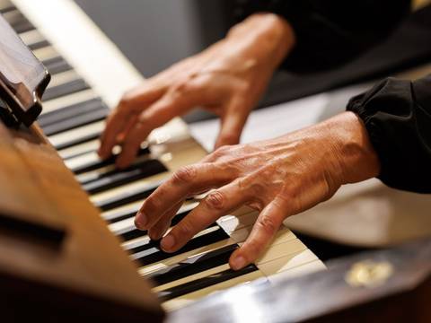 Orgelmusik als Brücke zwischen Vergangenheit und Gegenwart. – Nahaufnahme der Hände eines Organisten beim Orgelspielen