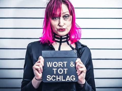 Wedding Slam Royale – Person mit pinkem Haar hält Schild mit der Aufschrift "WORT & TOT SCHLAG". Text: WEDDING SLAM ROYALE 20.09. - KI Slam 11.10. - TRUE CRIME Slam.