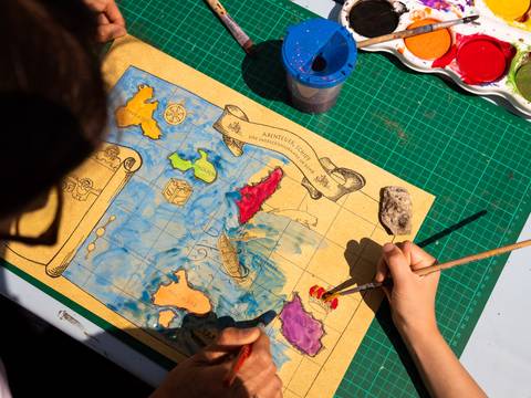 Technik kreativ: im Park – Eine Landkarte wird von einem Kind koloriert.