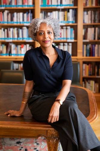 Portrait der Autorin Maaza Mengiste – Ein Frau sitzt vor einem Bücherregal