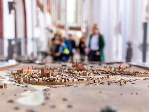 Modell der mittelalterlichen Stadt Berlin im Museum Nikolaikirche – Modell der mittelalterlichen Stadt Berlin im Museum Nikolaikirche, im Hintergrund unscharf Besucher und das Innere des Kirchenschiffs