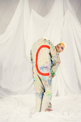 ABC – Das Maler-Alphabet – Zwei Personen in bemalten Overalls auf weißem Stoff. Eine Person trägt ein Outfit mit rotem "C", die andere hat gelbes Haar und blaues Gesicht.