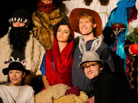  – Eine Gruppe verkleideter Personen; im Vordergrund Maerchenfiguren wie Rotkaeppchen und ein Hase; Hintergrund Kostueme mit Bart, Fell und Umhang.