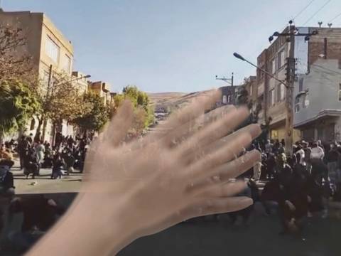 © Realillusion – Hände vor einer Menschenmenge auf einer Straße.