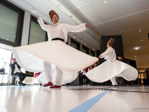 Veranstaltung „Mystische Dimensionen - Auf den Spuren berühmter Sufis" im Humboldt Forum – Zwei tanzende Personen in tradioneller weißer Kleidung