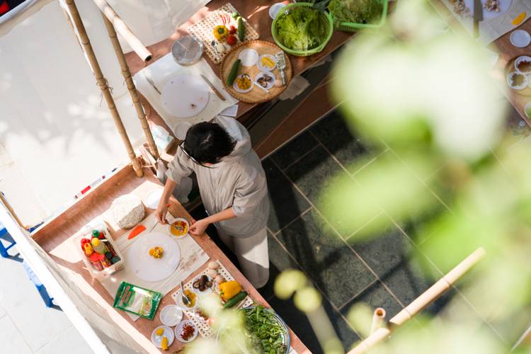 Koch-Performance des Kollektivs "groundtable" bestehend aus den Künstler*innen Gift Lalicha Lalitsasivimol und Kitman Pik Chee Yeung am Goethe Institut Hanoi – Koch bei der Vorbereitung aus der Vogelperspektive aufgenommen