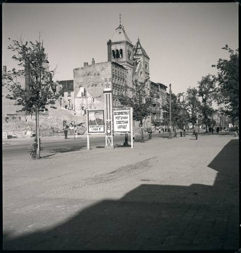 Das zerstörte Gebäude Müllerstraße 163 (links). Aufnahme von 1945. In der Bildmitte Propagandaplakate der Roten Armee: „Ruhm den besten Söhnen des Vaterlandes" (linkes Plakat), „Es lebe das kraftvolle sowjetische Volk" (rechtes Plakat) – Das zerstörte Gebäude Müllerstraße 163 (links). Aufnahme von 1945. In der Bildmitte Propagandaplakate der Roten Armee: „Ruhm den besten Söhnen des Vaterlandes" (linkes Plakat), „Es lebe das kraftvolle sowjetische Volk" (rechtes Plakat). © Landesarchiv