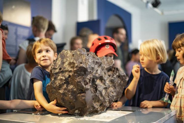 Kinder in der Archenhold-Sternwarte – Drei Kinder stehen vor Exponaten in der Archenhold-Sternwarte