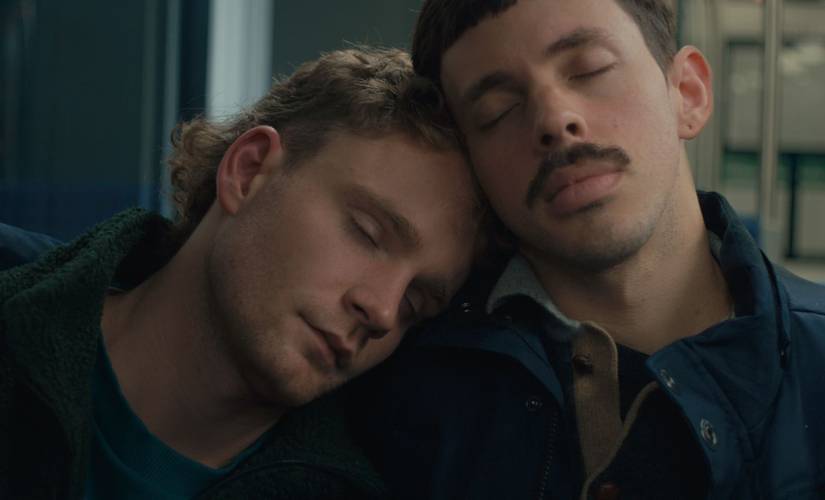 ‘For Those Who Love, ‘For Those Who Love, Leave, and Love Again’, G 2025, directed by Paolo Laganà © Lena Thiemann – Zwei Männer sitzen angelehnt aneinander und haben die Augen geschlossen.