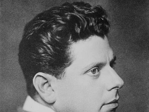Reinhardt, Max – Männlich gelesene Person im Profil, lockiges Haar, Anzug. Text: Nicola Perscheidt 1911.