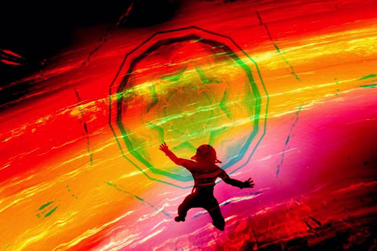 Still aus dem Fulldome-Programm Imagine Dragons: Dimensional Voyager – Silhouette einer Person vor leuchtendem, psychedelischem Tunnel mit intensiven Farben.