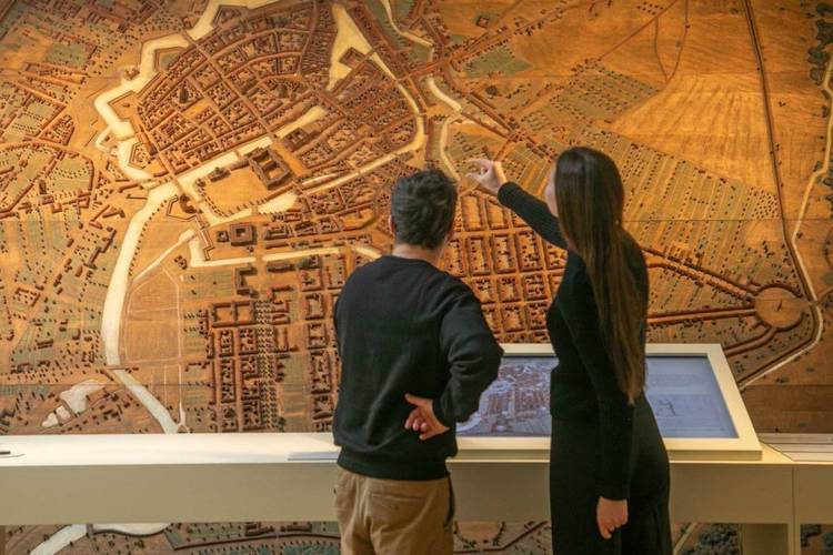 So klein war Berlin früher … Entlang von originalen Objekten, digitalen Medienstationen und großformatigen Modellen geht‘s in einer Stunde durch 800 Jahre Geschichte. – Besucherin und Besucher vor einem Stadtmodell mit Medienstation