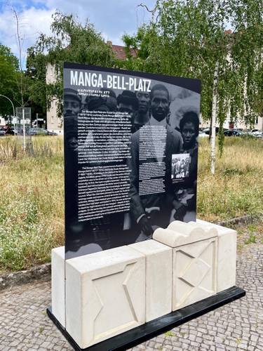 Anstelle des Reichskommissars Gustav Nachtigal, der die Grundlagen für die deutsche Kolonialherrschaft in West-Afrika schuf, wird am Manga-Bell-Platz nun der antikolonialen Widerstandskämpfer:innen Rudolf und Emily Duala Manga Bell gedacht. – Gedenkstele für die antikolonialen Widerstandskämpfer:innen Rudolf und Emily Duala Manga Bell am Manga-Bell-Platz