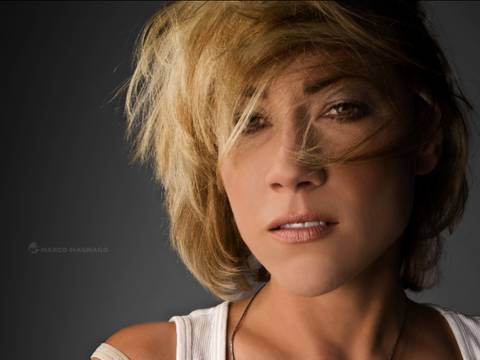 Shannon Callahan – Person mit kurzem blondem Haar, leicht zerzaust, blickt in die Kamera. Weiße Kleidung. Text: Marco Magnago.