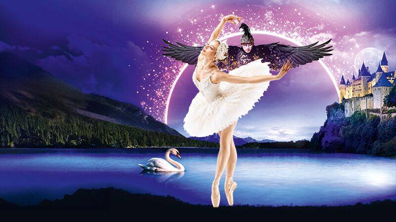 Ballettänzerin in weißem Kostüm tanzt vor See mit Schwan, Burg im Hintergrund, Farbverlauf Himmel mit rosa und blau. Engel mit Flügeln über Tänzerin.