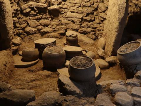 Steingefäße, Platten und Klopfsteine in Fundlage in einem Küchenbereich in Karahantepe, 9400–8000 v.Chr.