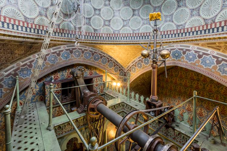Dampfmaschinenhaus (Moschee), Maschinenraum, oberster Treppenabsatz unter der Kuppel mit Fliehkraftregler und Adler – Maschinenraum des Dampfmaschinenhauses (Moschee) mit kunstvoll verziertem Gewölbe und Metallgestänge. Dampfmaschine in der Mitte. Reiche Muster und Ornamente bedecken Wände und Decke.